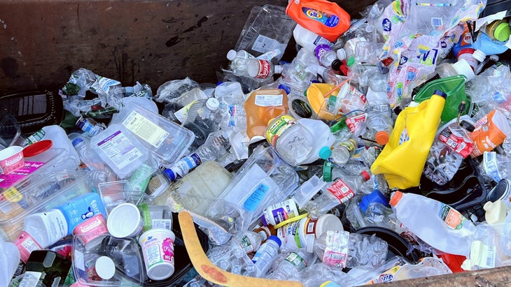 Assorted plastic bottles and containers in a recycling bin