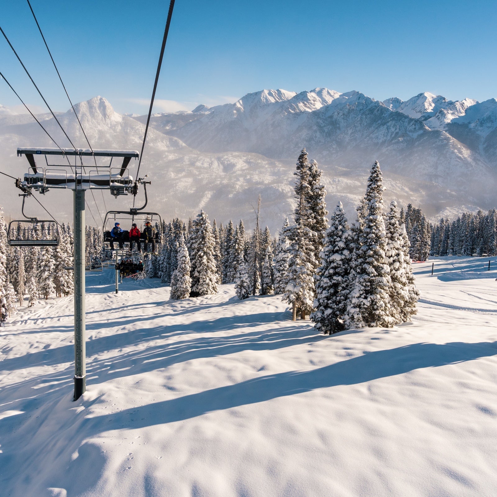 Skiers ride the lift up to the top of Purgatory Resort, in Colorado. The whole landscape is covered in powder.