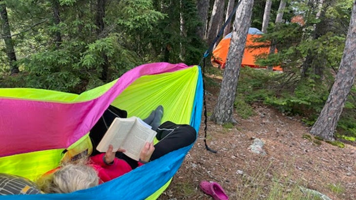 Stephanie Pearson reads a book at a campsite