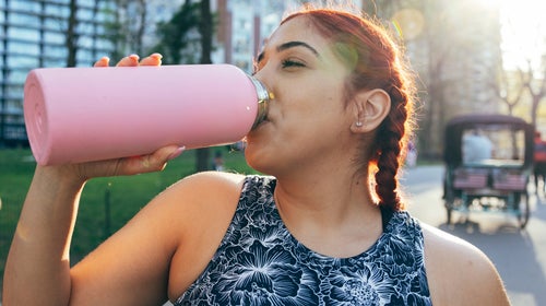 Woman drinking from a water bottle.