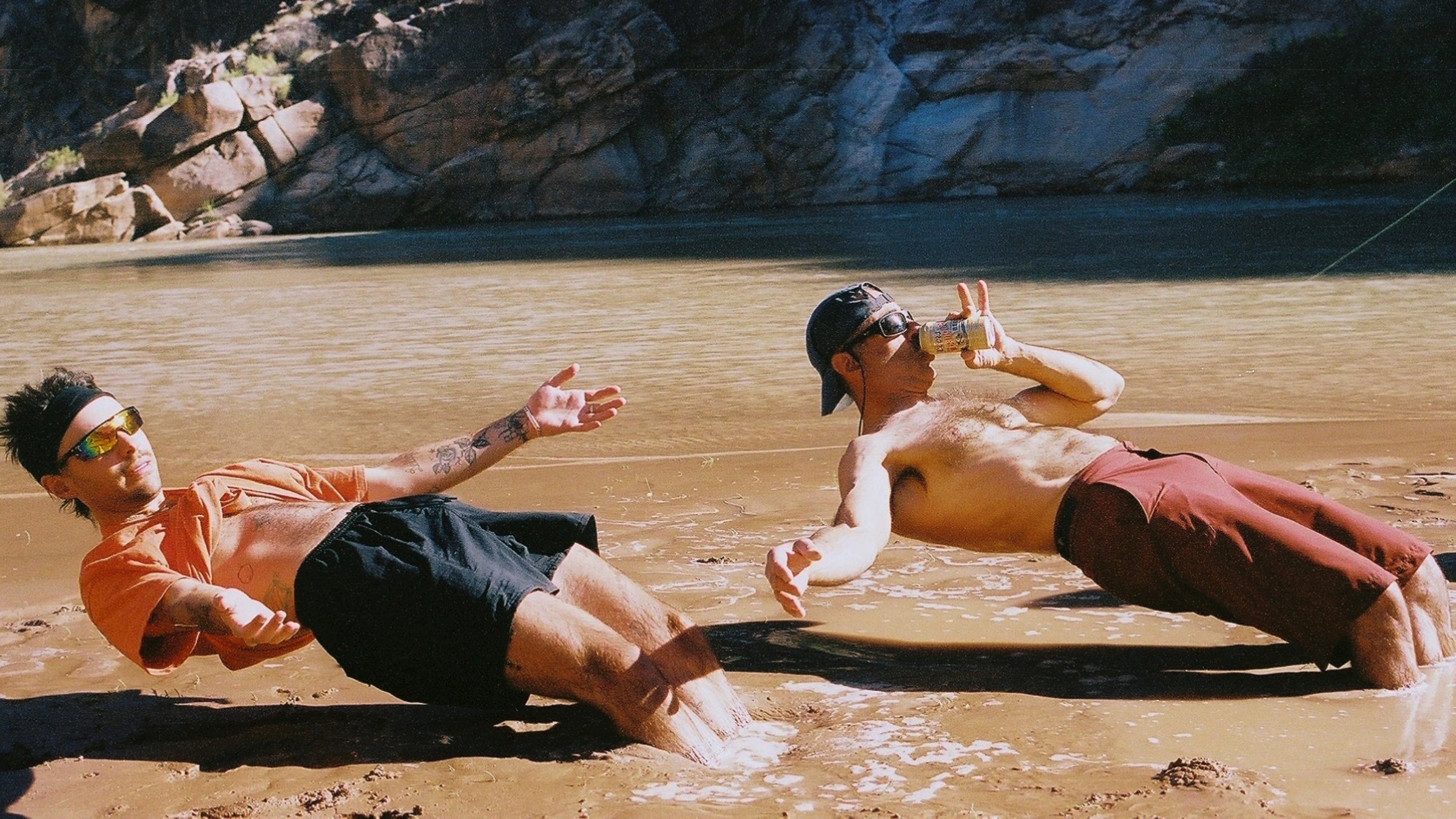 two people relax in a muddy river