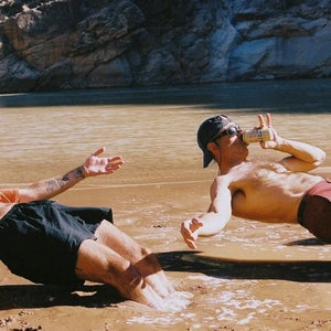 two people relax in a muddy river