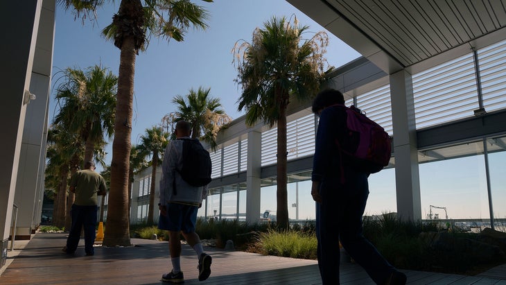 Passengers walk through a garden area between terminals at Long Beach Airport