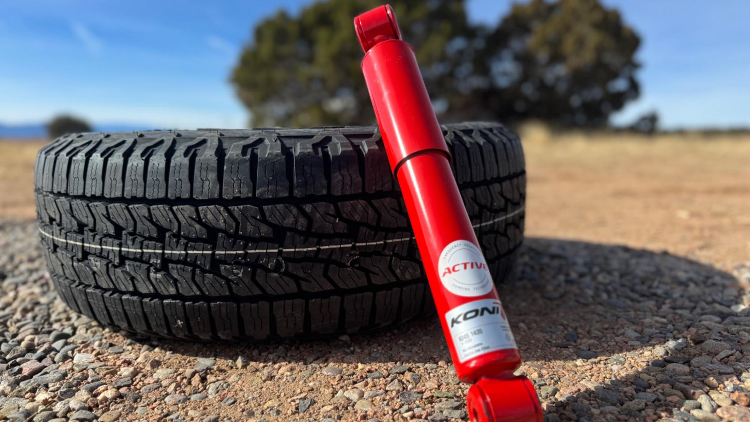 Closeup of Koni suspension and all-terrain tire on dirt road