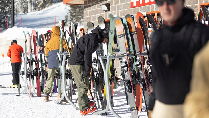 Skiers hanging out by ski rack at SKI's annual gear test