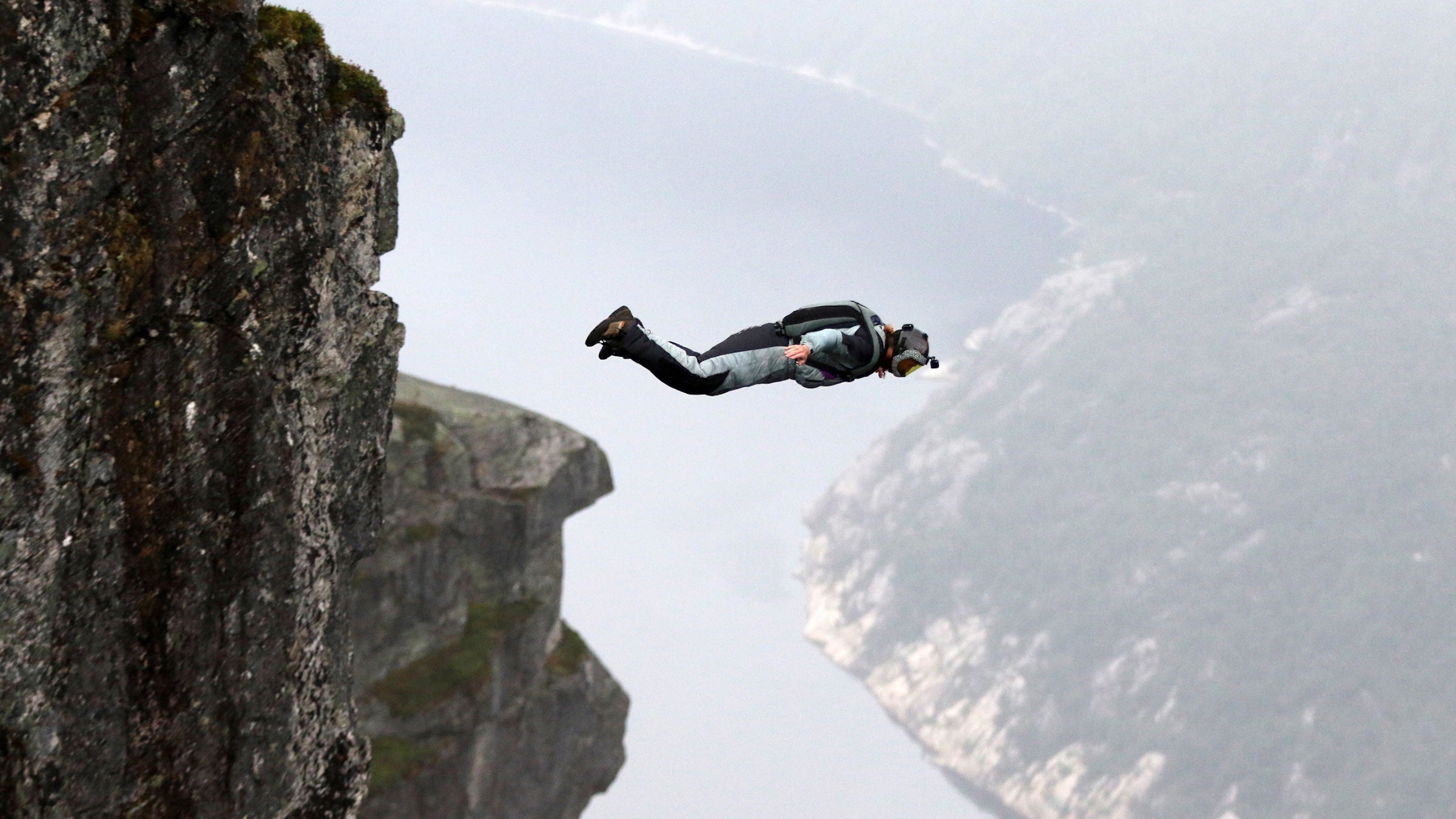 man jumping off of a cliff in Norway