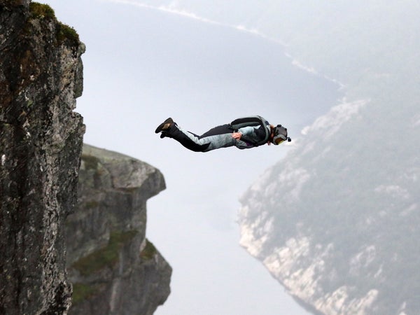 man jumping off of a cliff in Norway
