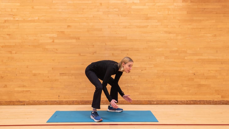 A woman coming up from a deep squat