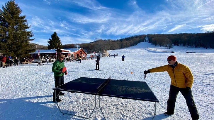 two skiers play some après ping pong at the White Grass Ski Touring Center