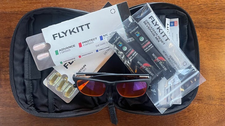 The contents of a FlyKitt, unzipped and on display: a pair of orange-lens glasses and various supplements in blister packs