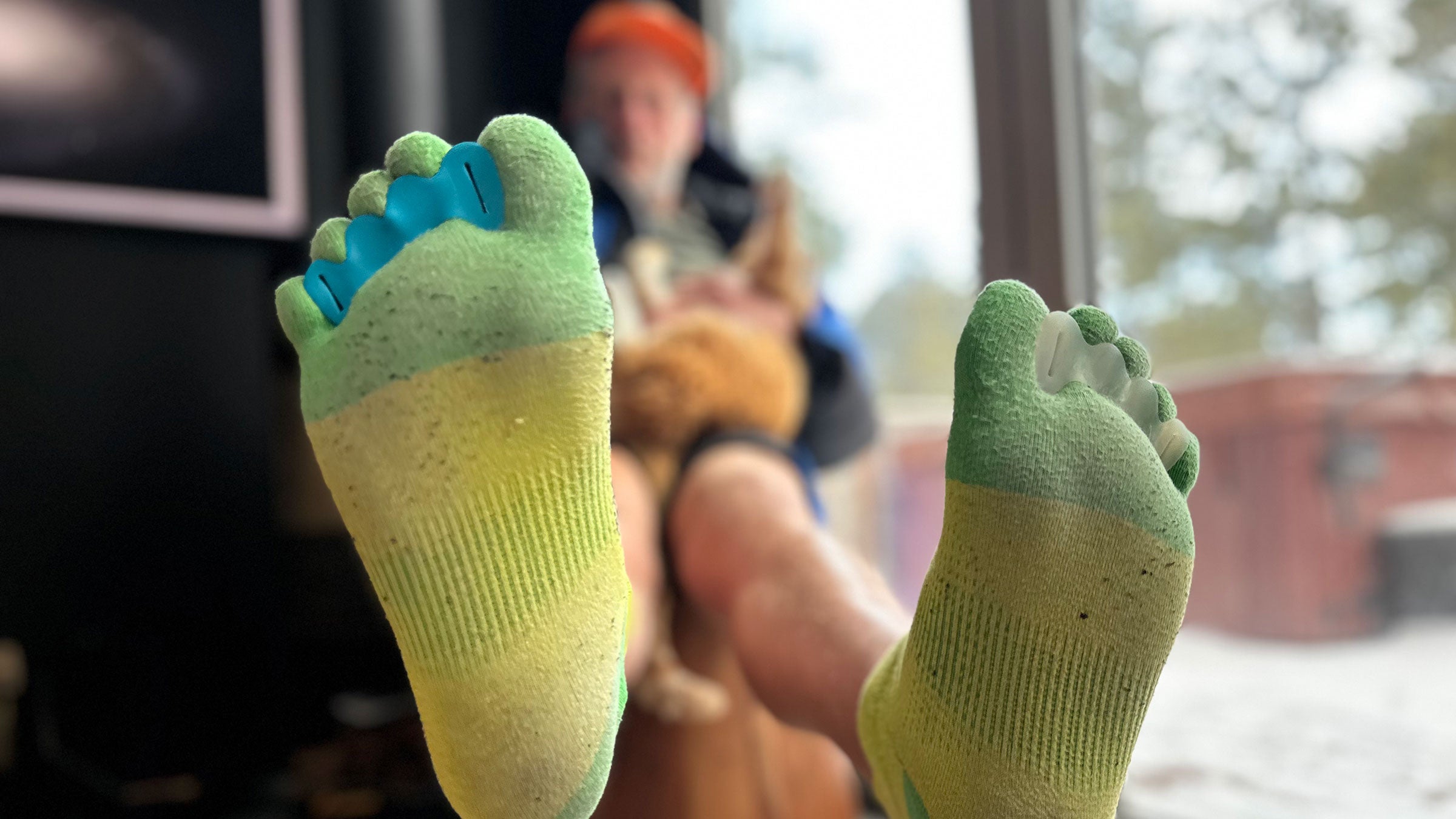 Grayson Haver Currin sitting on a chair showing toe spacers and toe socks