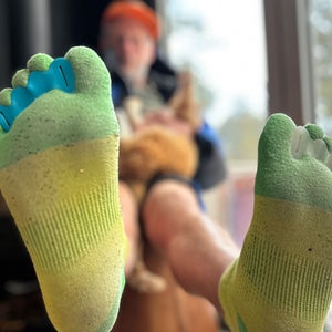 Grayson Haver Currin sitting on a chair showing toe spacers and toe socks