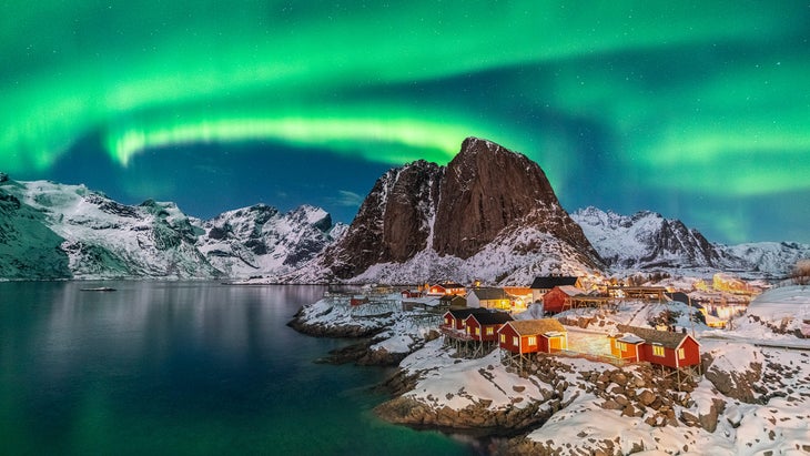 Northern lights above Festhelltinden peak and Hamnoy, Lofoten archipelago, Norway