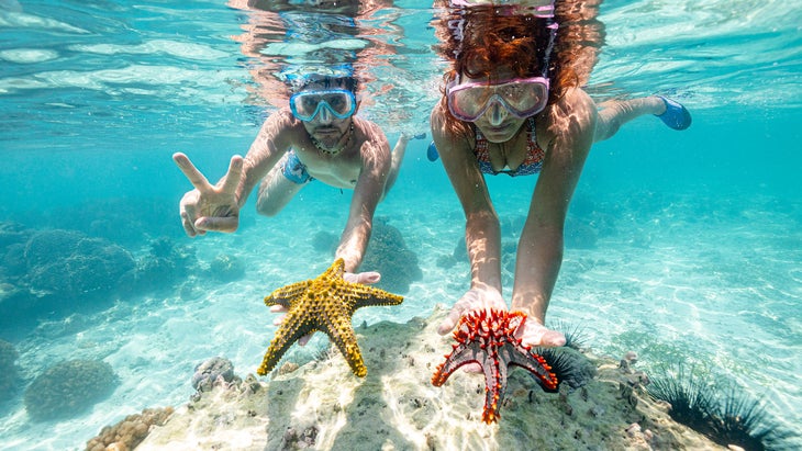 man and woman snorkel in Zanzibar