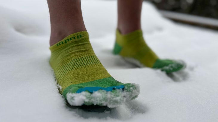 grayson haver currin stands in the snow with toe socks and toe spacers