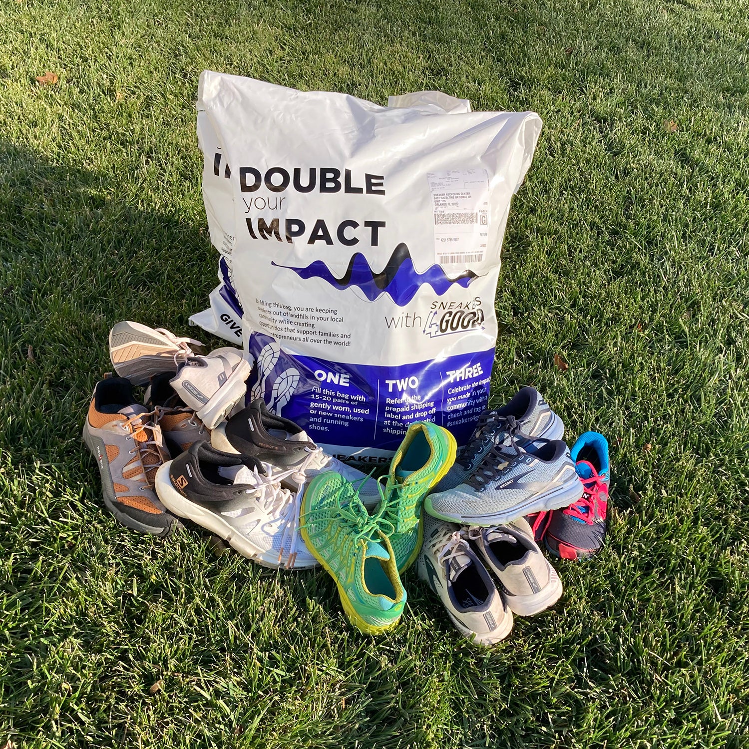 pile of used running shoes and donation bag