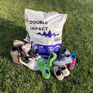pile of used running shoes and donation bag