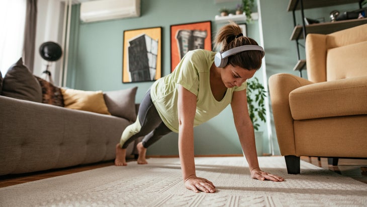 a woman does a pushup in her living room