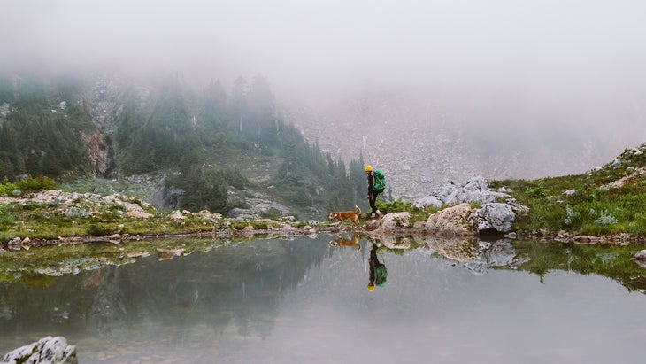 hiker and misty lake in Strathcona Provincial Park, British Columbia