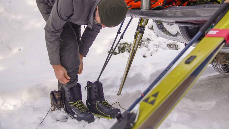 A man getting ready to put on his cross-country ski gear