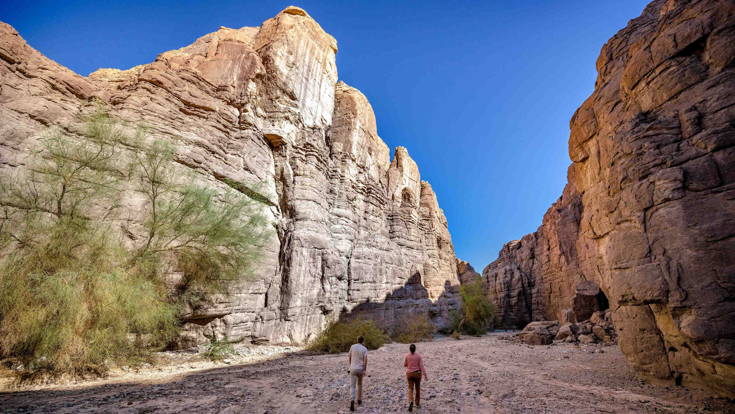 two people hike in a canyon