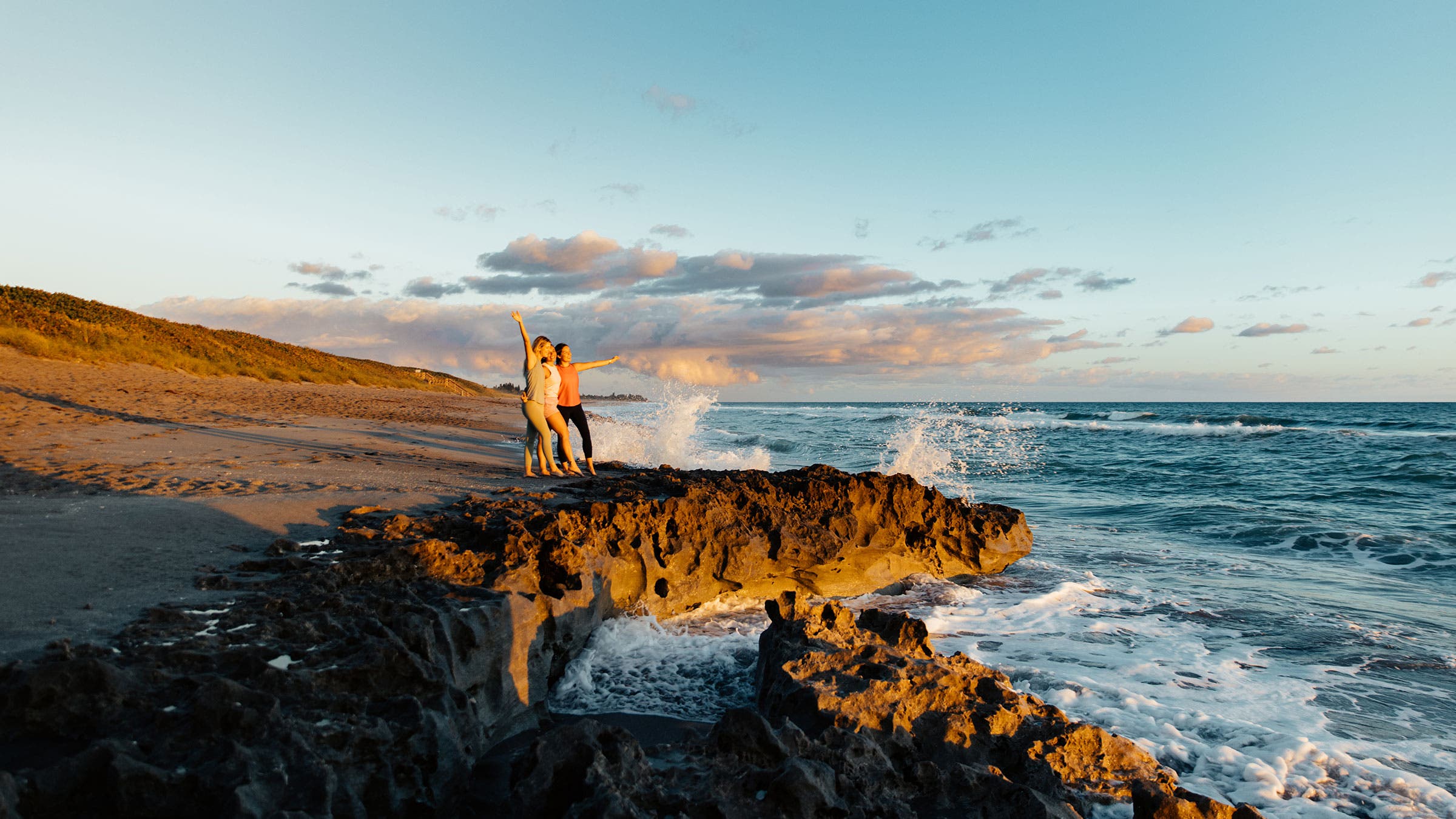 three women enjoying salty oceanspray at blowing rocks preserve near jupiter beach