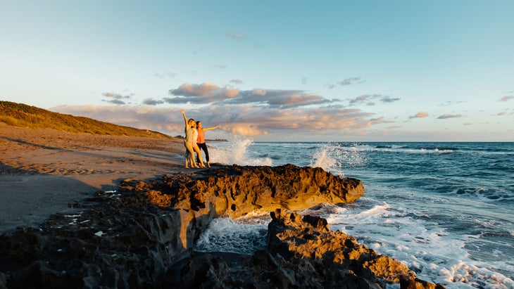 three women enjoying salty oceanspray at blowing rocks preserve near jupiter beach