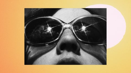 A woman wears dark sunglasses and receives vitamin D from the sun