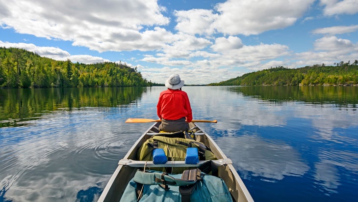 man paddling a canoe in the Boundary Waters Canoe Area Wilderness in Minnesota—a perfect place to go on vacation this year