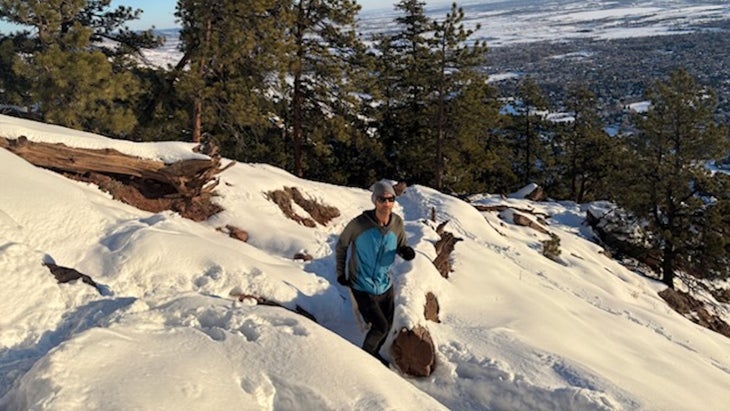 man running up trail in snow