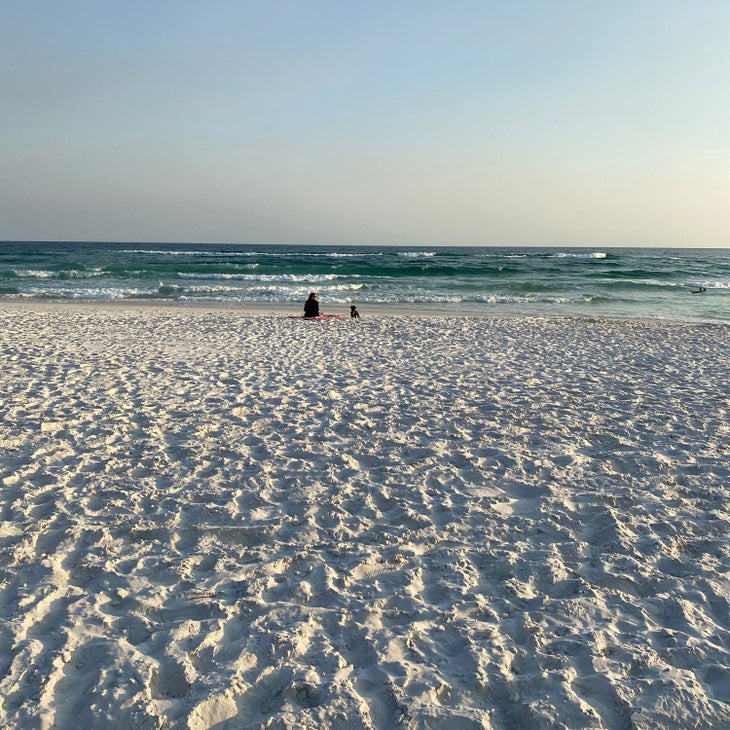 woman sitting with her dog on Grayton Beach in Florida