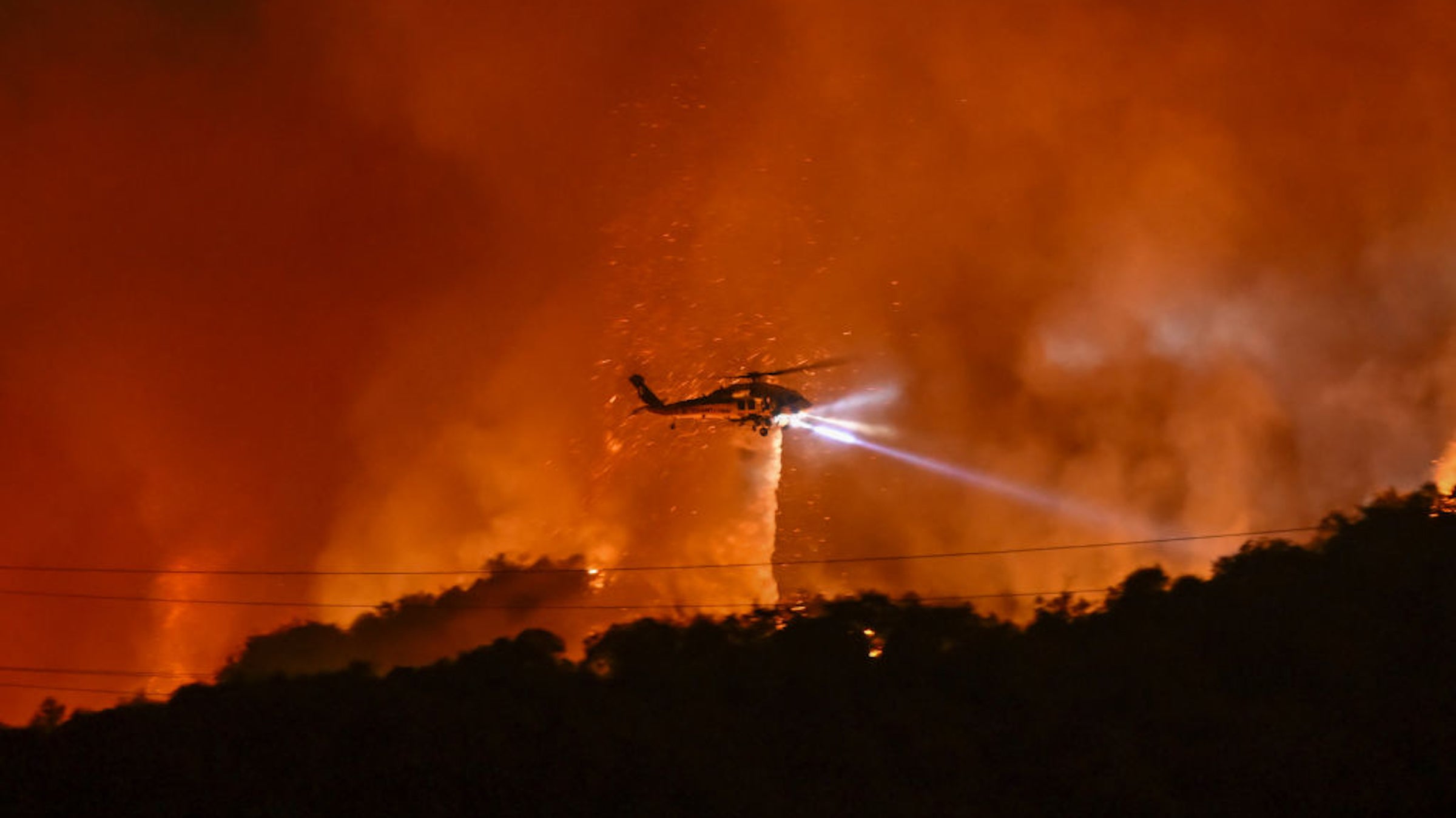 helicopter above bright red and orange sky