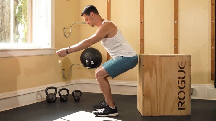 man squats in front of a box with his backside touching it as one of the hip exercises for skiers