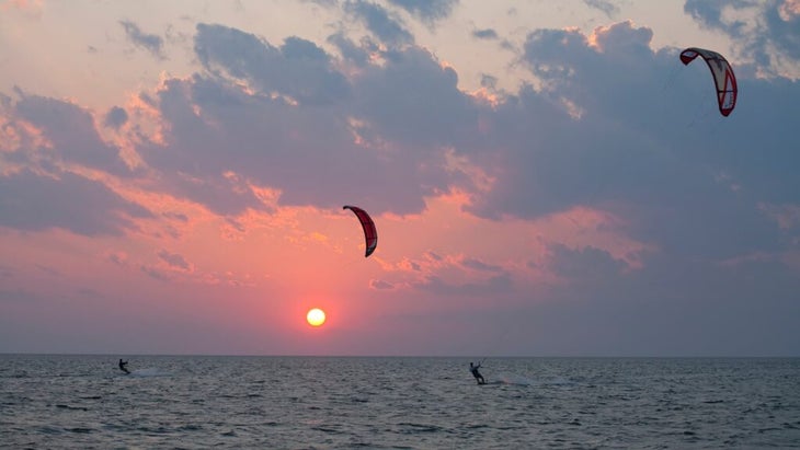 Two kiteboarders harness the wind on North Carolina's Pamlico Sound near sunrise. 