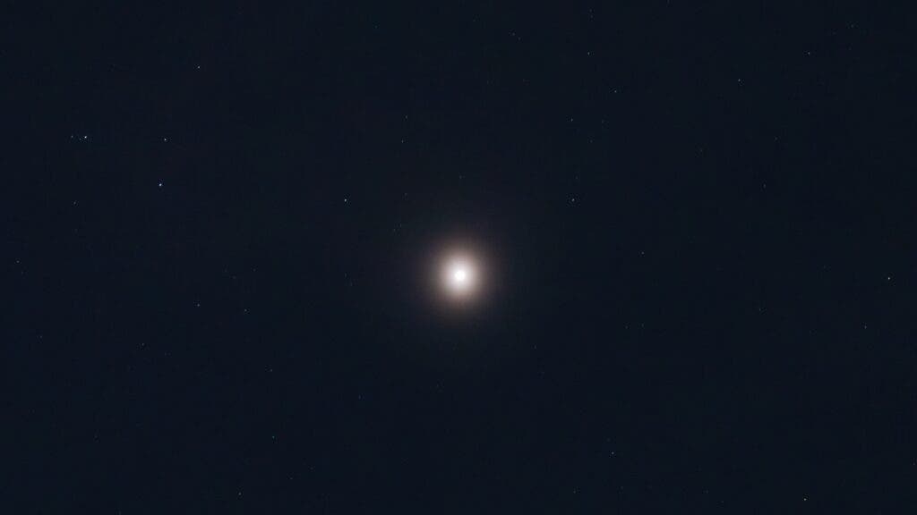 The author shot a photo of Mars at night from light-polluted San Diego and it's glowing very brightly amid the skycape and surrounding stars.