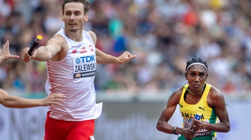 Karol Zalewski of Poland and Natoya Goule-Toppin of Jamaica compete in a Mixed 4x400 Meters Relay heats at the World Athletics Championships