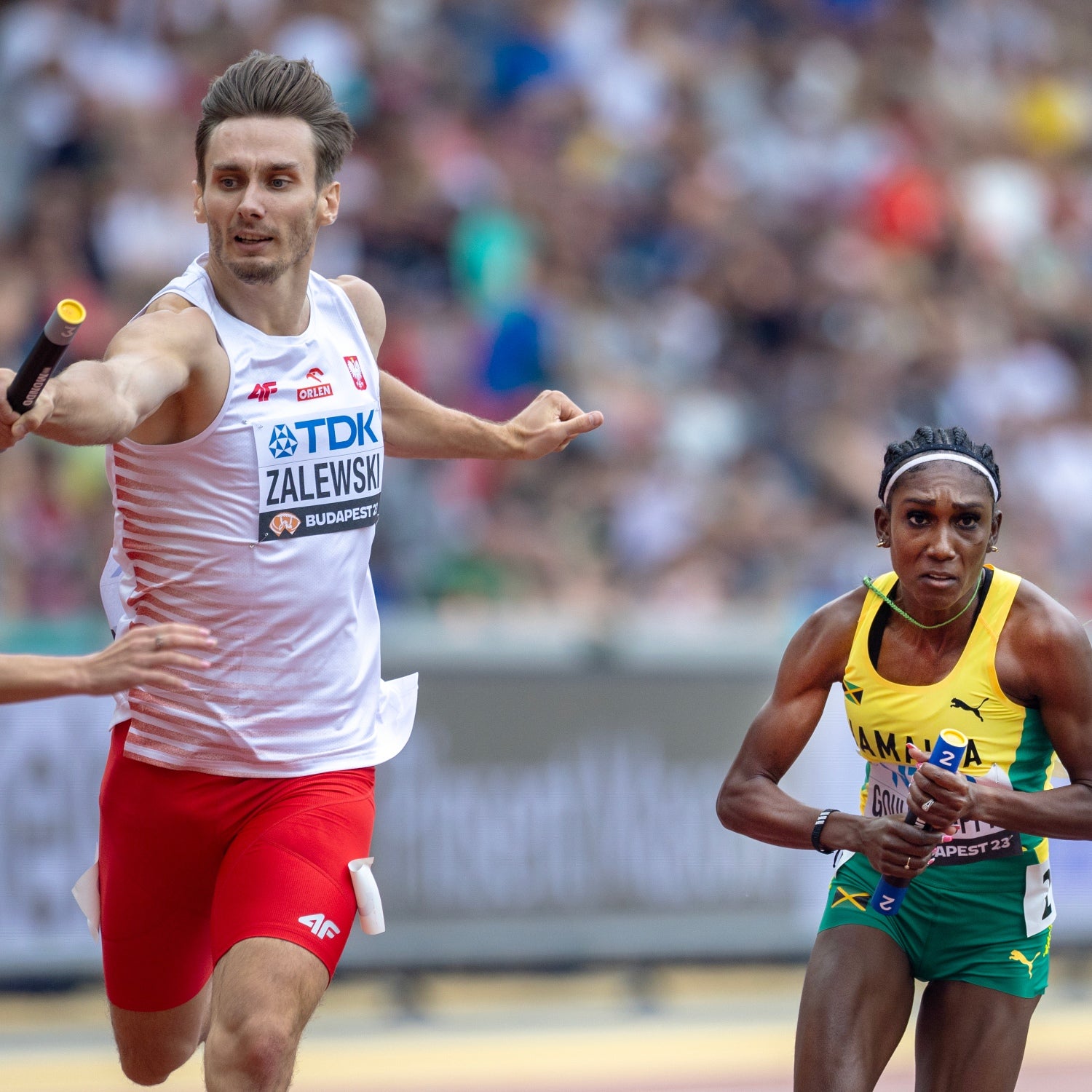 Karol Zalewski of Poland and Natoya Goule-Toppin of Jamaica compete in a Mixed 4x400 Meters Relay heats at the World Athletics Championships