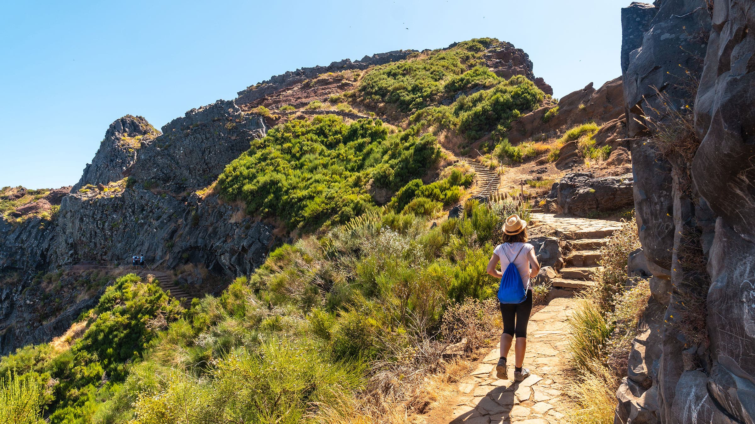 A young woman walking toward Pico do Arieiro from Ninho da Manta viewpoint in Portugal
