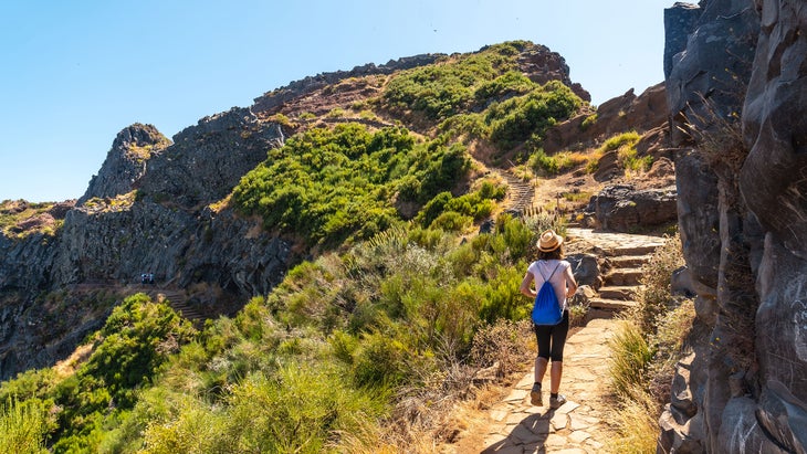 A young woman walking toward Pico do Arieiro from Ninho da Manta viewpoint in Portugal