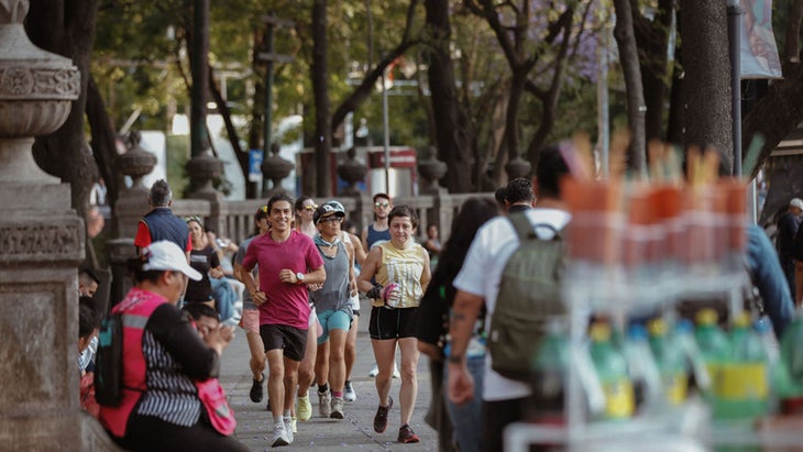 Runners pass through a green park in Mexico City