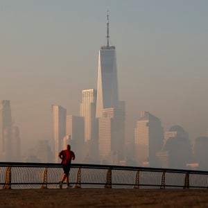 The Manhattan skyline shrouded in air pollution, with a lone runner in the foreground.