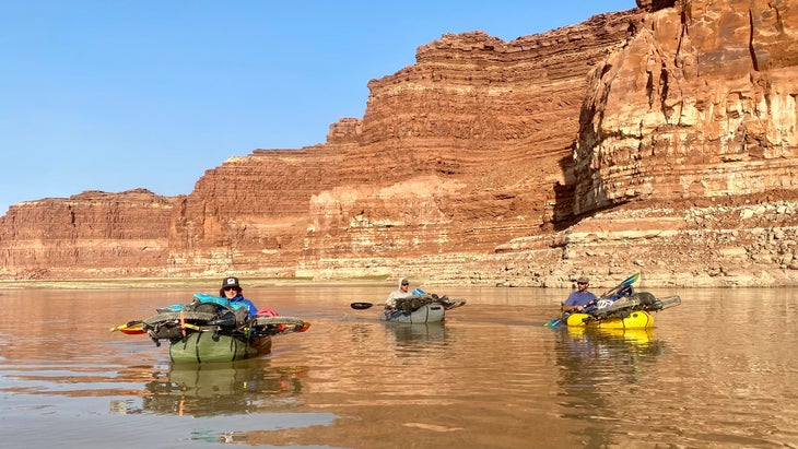 smiling woman and friends packrafting in Glen Canyon