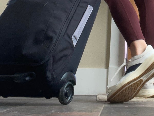 woman wearing versatile running gear with carry-on bag