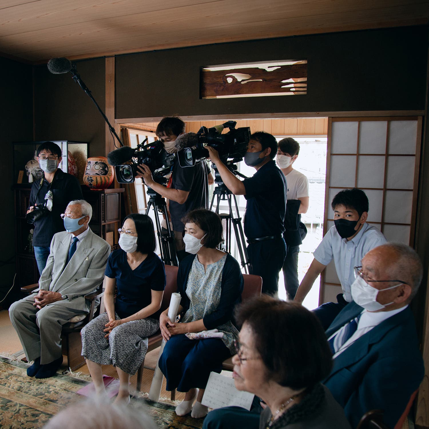 Umeki relatives and Japanese news-agency reporters watch the hand-off