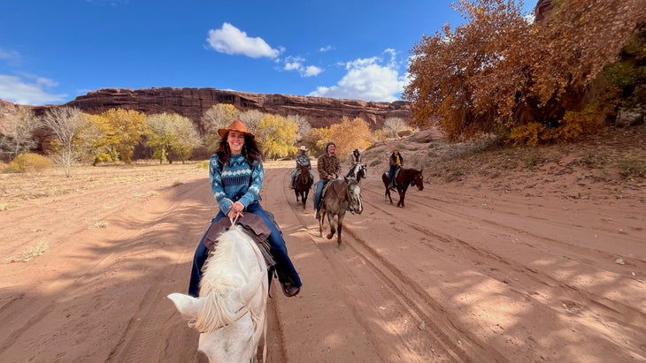 group riding on horseback through canyon