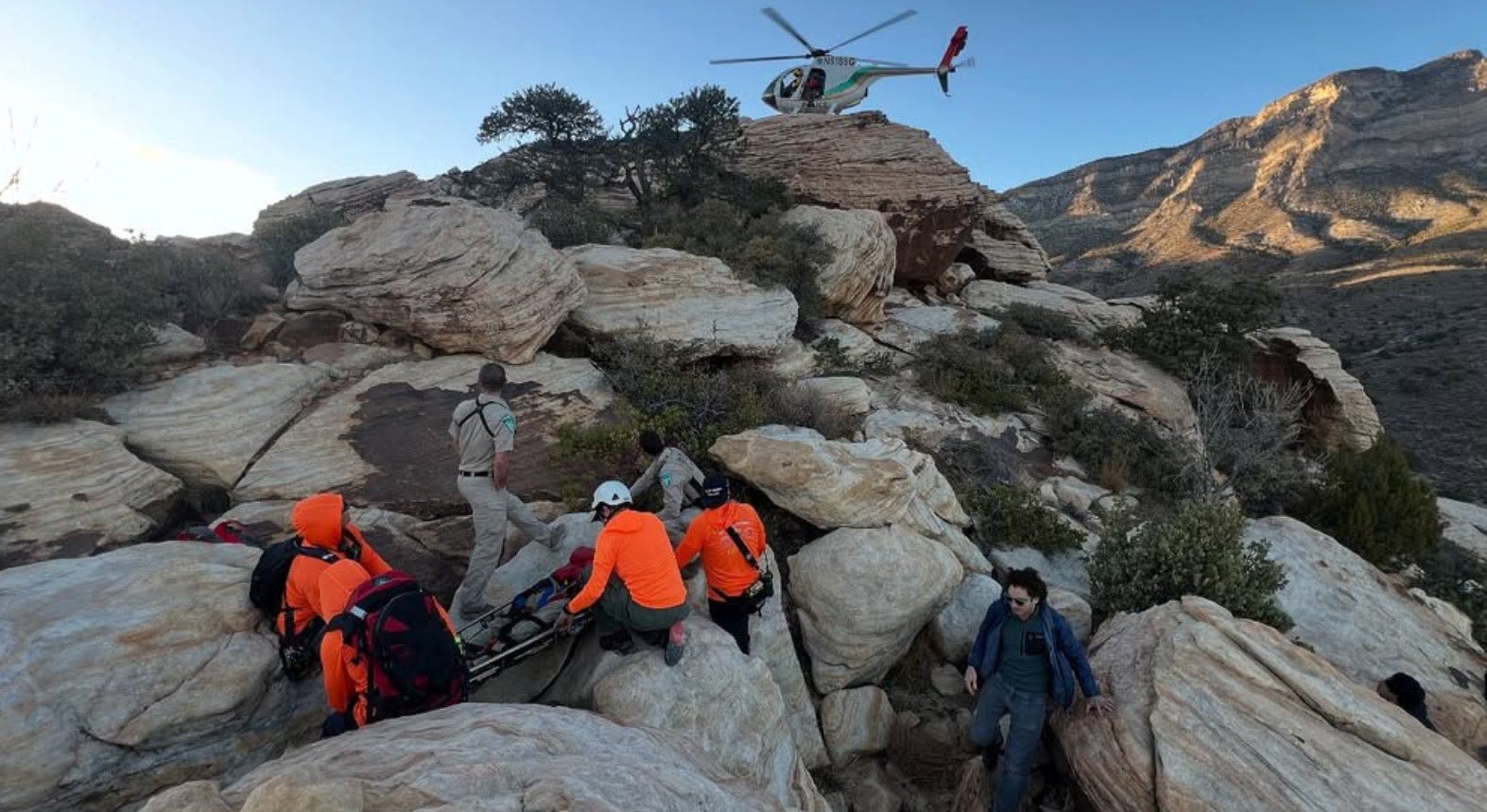 rescue team on rocks in orange jackets