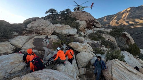 rescue team on rocks in orange jackets