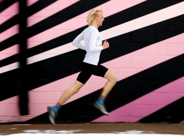blond runner against pink wall art