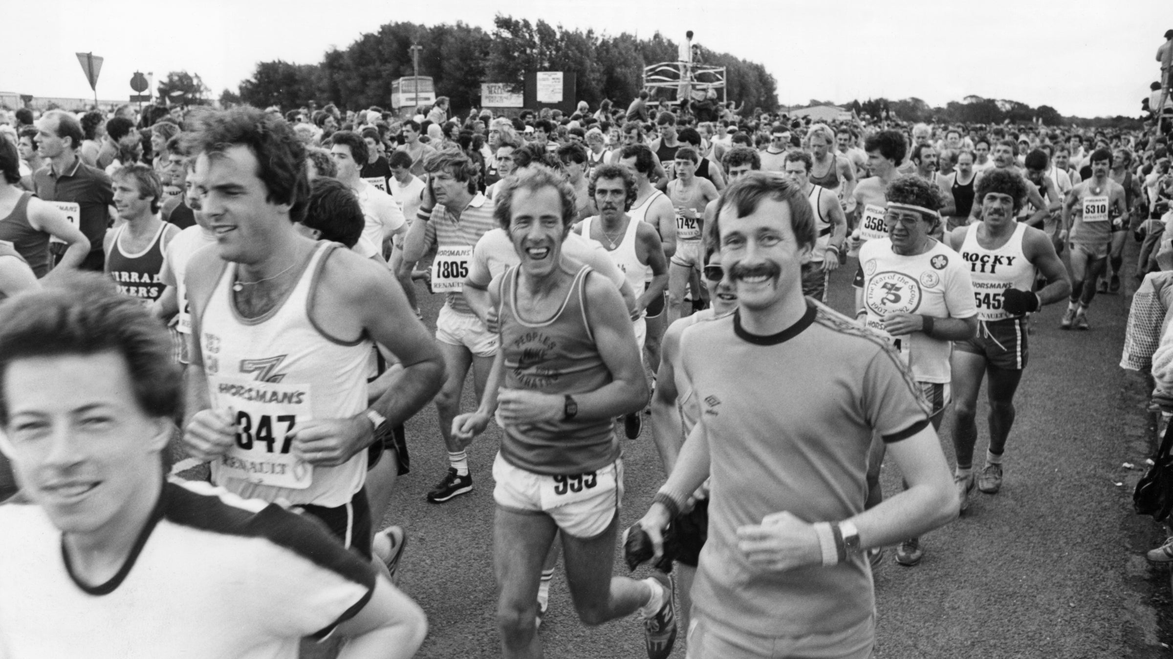 A large group of runners begins the Mersey Marathon with big smiles on their faces