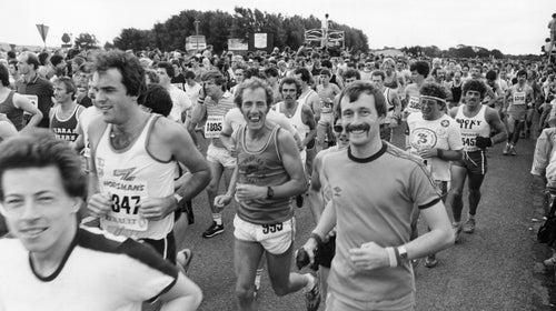 A large group of runners begins the Mersey Marathon with big smiles on their faces